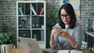 woman using cell phone with blue light filtering glasses